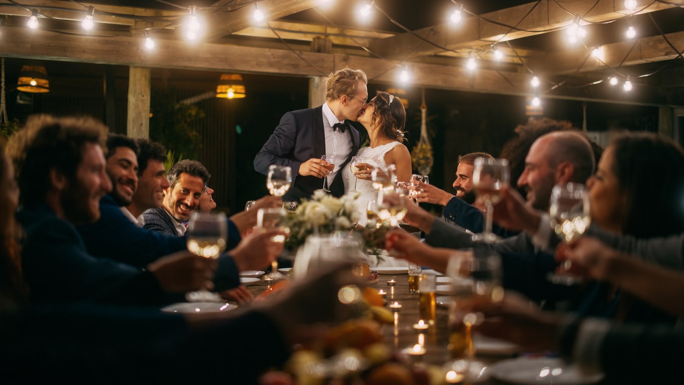 Les nouveaux mariés s'embrassent, invités trinquent au restaurant charmant de Fréjus.