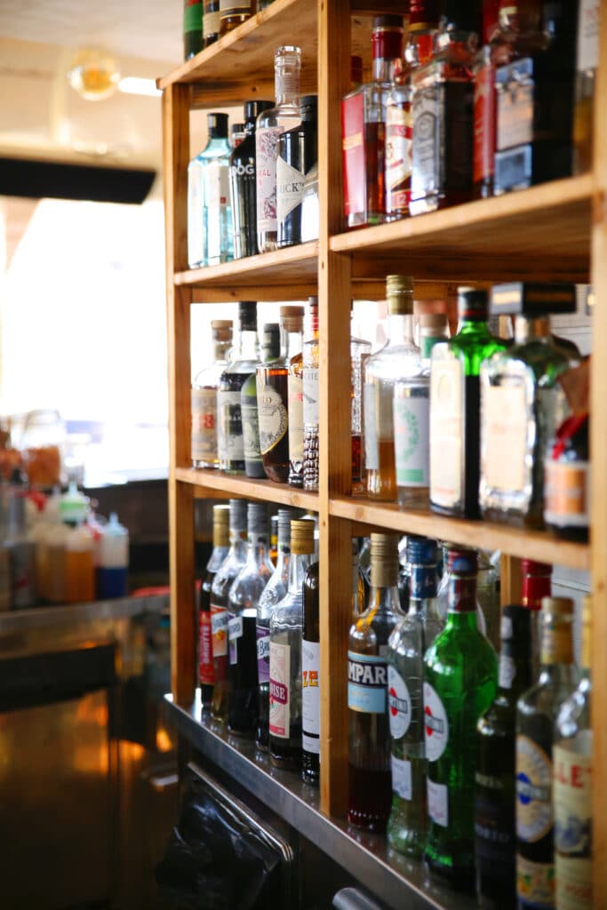 Etagère en bois avec bouteilles de liqueur.