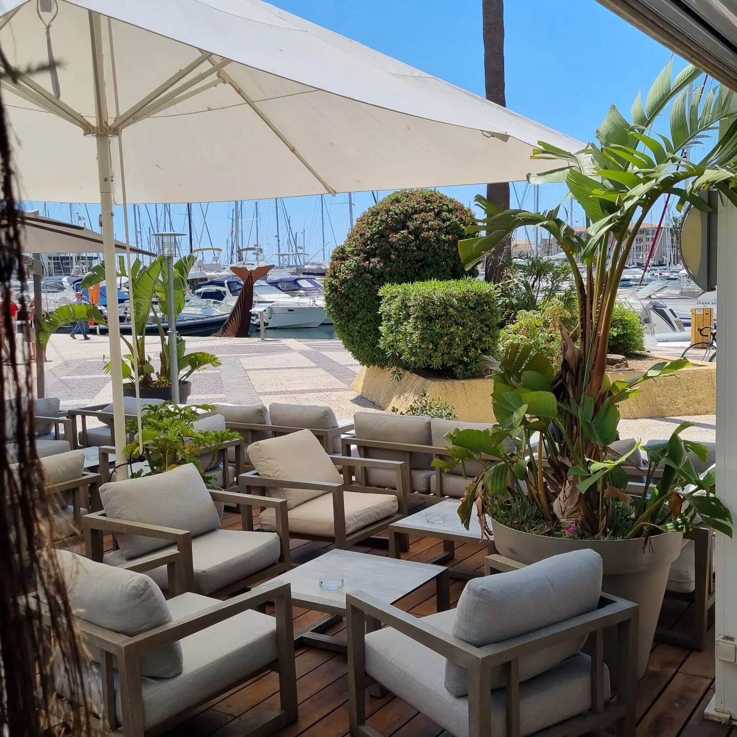 Terrasse avec chaises confortables et vue marina.