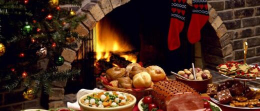 Aliments de fêtes comme le jambon, les desserts et le pain; ambiance festive avec bas et sapin.